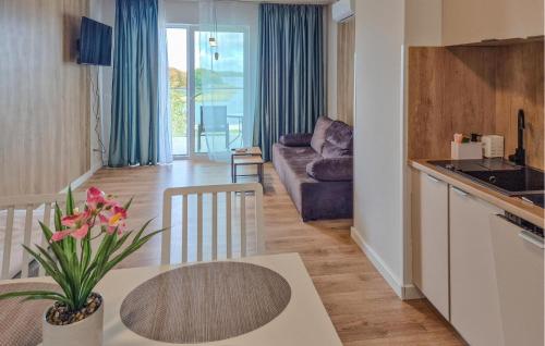a kitchen and living room with a table and a couch at Beautiful Apartment In Insko With Sauna in Ińsko