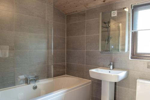 bagno con vasca, lavandino e motivi tubermotter di Harvest 12 Lodge, Yellowtop Country Park a York