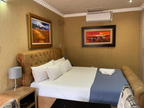a hotel room with a bed and a couch at Romans Rest Guest House in Carletonville