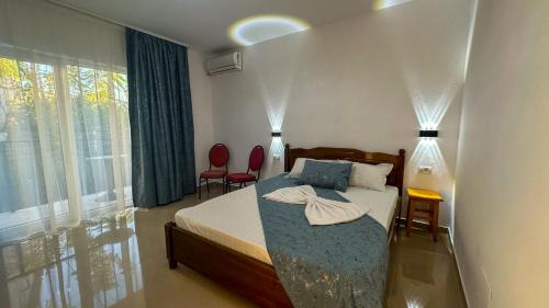 a bedroom with a bed and two red chairs at VIP next TIME Casa Vacanta in Costinesti