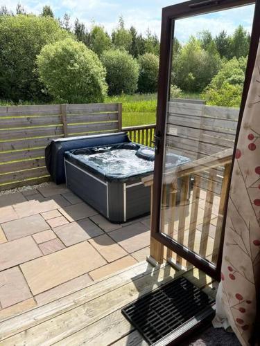 a hot tub sitting on top of a deck at Wild Oats Lodge 17, Yellowtop Country Park in York