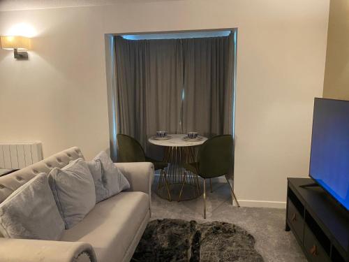 a living room with a couch and a small table at Nw2 Studio Flat mins to London in London