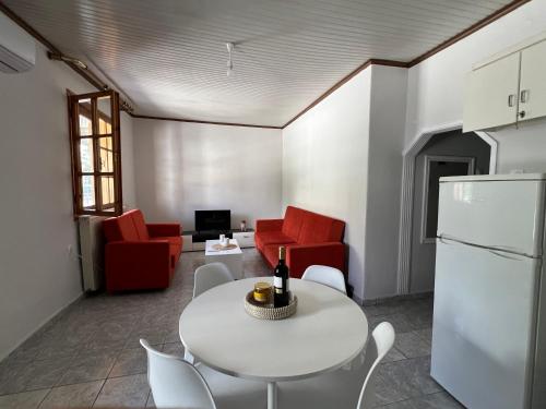 a living room with a white table and red chairs at 60s Homestead in Chrysoupolis