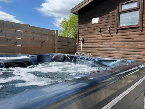 a hot tub with water coming out of a house at Wild Oats Lodge 17, Yellowtop Country Park in York