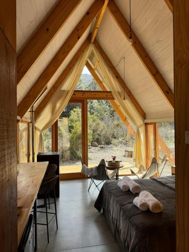 a bedroom in a house with a large window at El Diucón Eco Lodge in Lago Meliquina