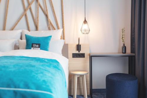 a bedroom with a bed and a stool and a table at Holiday Inn - the niu, Yen Hamburg City by IHG in Hamburg