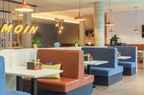 a restaurant with blue chairs and tables at Holiday Inn - the niu, Yen Hamburg City by IHG in Hamburg