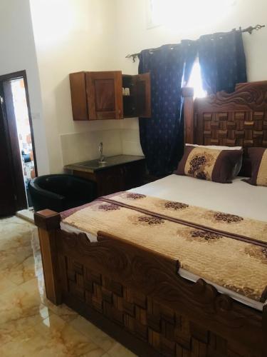 a bedroom with a large bed with a wooden headboard at SunuSal One Bedroom Studio Apartment SS3-CHERNO in Sere Kunda