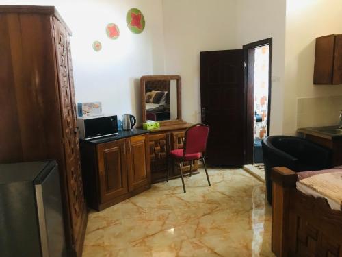 a room with a desk with a mirror and a red chair at SunuSal One Bedroom Studio Apartment SS3-CHERNO in Sere Kunda