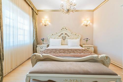 a bedroom with a king sized bed with a chandelier at Elegance East Hotel in Antalya