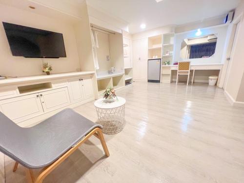 a large living room with a chair and a tv at The Space Hotel Chiang Rai in Chiang Rai
