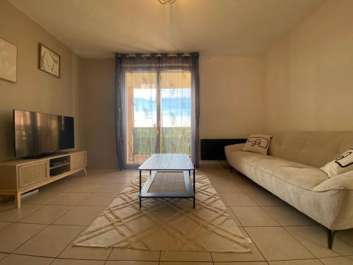 un salon avec un canapé et une télévision dans l'établissement T2 Tout Confort - Parking Gratuit, à Carcassonne