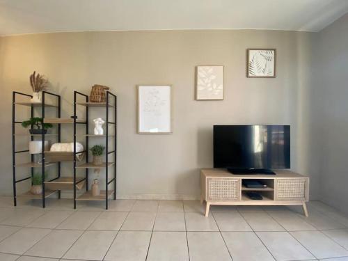 - un salon avec une télévision à écran plat et des étagères dans l'établissement T2 Tout Confort - Parking Gratuit, à Carcassonne
