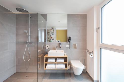 a bathroom with a shower and a sink and a toilet at Holiday Inn - the niu, Kettle Stuttgart Vaihingen by IHG in Stuttgart