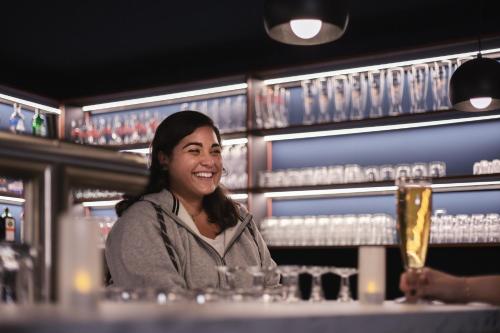 a woman sitting at a table in a bar at Holiday Inn - the niu, Kettle Stuttgart Vaihingen by IHG in Stuttgart