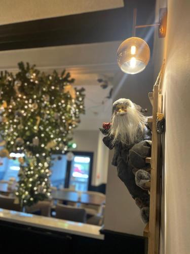 a santa claus statue on a wall next to a christmas tree at The Lilly Restaurant With Rooms in Llandudno