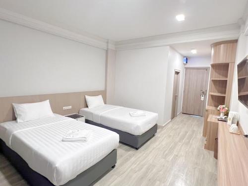 a hotel room with two beds and a book shelf at The Space Hotel Chiang Rai in Chiang Rai