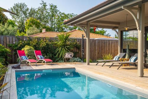 une piscine avec deux chaises et un pavillon dans l'établissement Superbe maison climatisée avec piscine, à La Teste-de-Buch