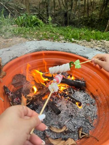a group of people playing around a fire at Sítio São Pedro de Alcântara com Spa Sauna in São José