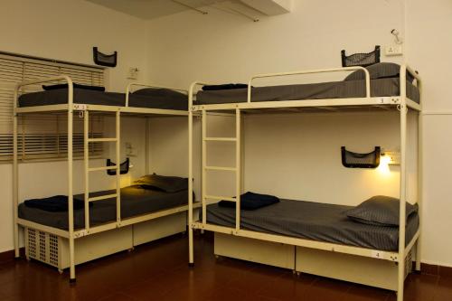 a room with three bunk beds in a room at Summer Hostel in Palolem