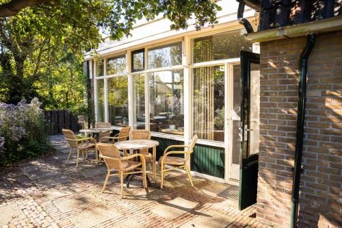 a patio with tables and chairs in front of a window at Hotel De Horper Wielen in Kaard