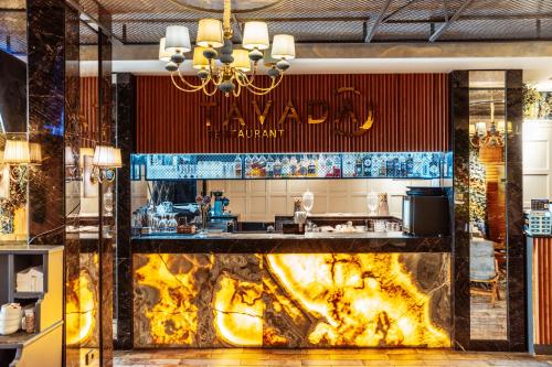 a bar in a restaurant with a large fireplace at Theatrum Hotel Baku in Baku