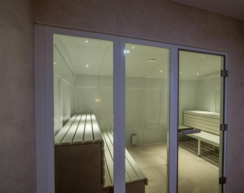 a room with glass doors and a room with a bed at Flor Da Rocha in Portimão