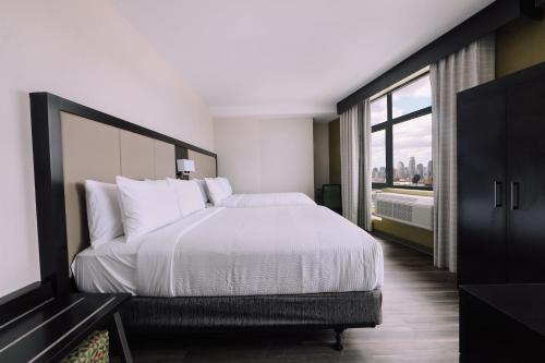 a bedroom with a large bed and a large window at Holiday Inn Express Long Island City E - New York by IHG in Queens