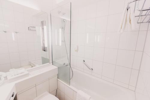 a bathroom with a shower and a toilet and a sink at elaya hotel stuttgart ludwigsburg ehemals Abacco by Rilano in Korntal-Münchingen