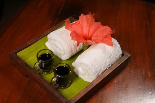 a tray with two towels and two glasses on it at Blackberry Hills Munnar Nature Resort & Spa in Munnar