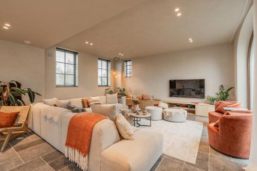 a living room with a couch and a tv at Botanic Experience Holiday House in Oostkamp