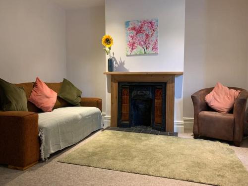 a living room with two couches and a fireplace at Cute centrally located flat in Bristol