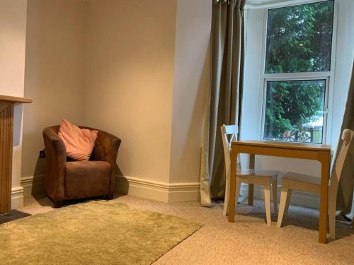 a living room with a chair and a desk and a window at Cute centrally located flat in Bristol