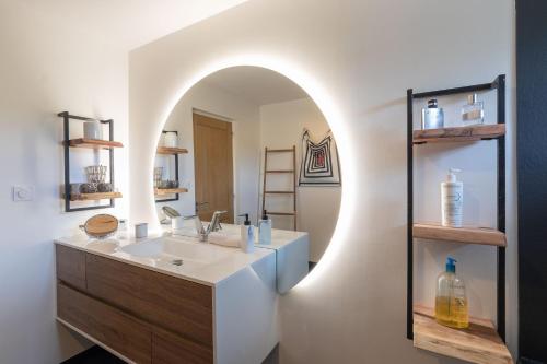 une salle de bain avec un lavabo et un miroir dans l'établissement Maison Clos des Renauds, à Charbonnières