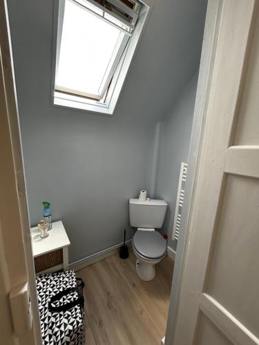 a bathroom with a toilet and a window at Rayon De Soleil in Courseulles-sur-Mer