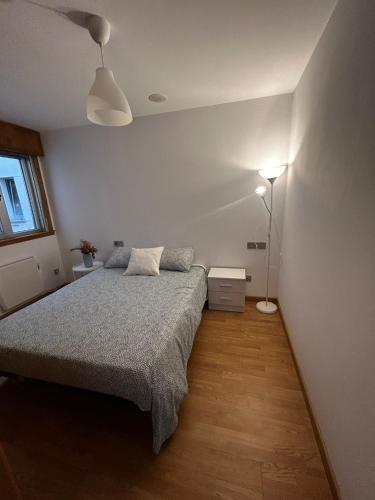 a bedroom with a bed and a lamp at Malpica Beach in Malpica