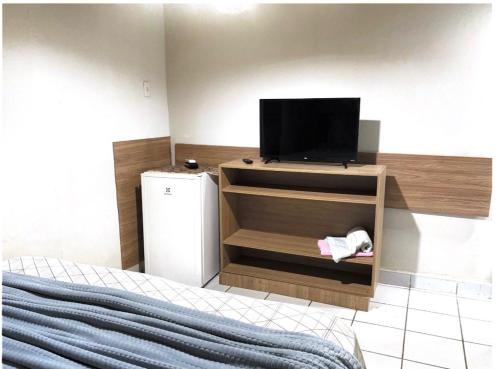 a bedroom with a bed and a tv on a cabinet at Pousada Porto de Paz - Noronha in Fernando de Noronha
