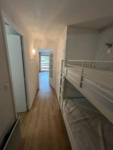 Cette chambre comprend 2 lits superposés et un couloir. dans l'établissement Studio Grand Stemm Pla d'Adet, à Saint-Lary-Soulan