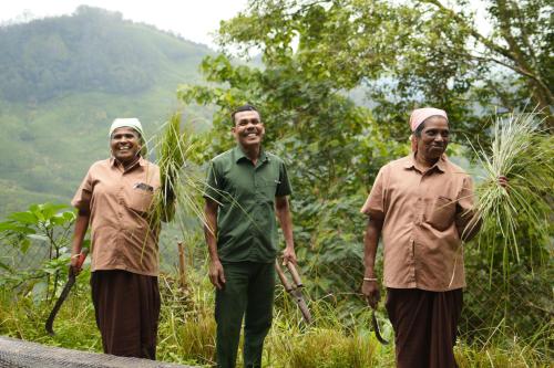 a group of three men standing on the side of a road at Blackberry Hills Munnar Nature Resort & Spa in Munnar