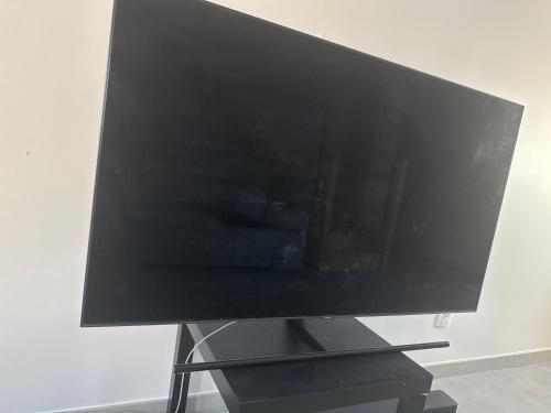 un téléviseur à écran plat posé sur une table dans l'établissement Maison cosi, à Villefontaine