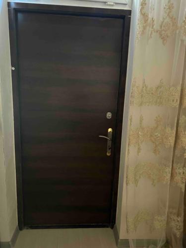 Una puerta negra en una habitación con una cortina. en Lena home, en Ereván