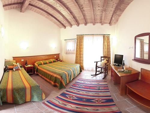 a bedroom with two beds and a television in a room at Gelindo dei Magredi Casa Gialla in Vivaro