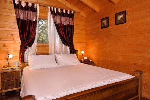 En eller flere senge i et værelse på Spa Chalets In Olive Grove