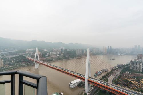 a bridge over a river with a city in the background at King'sLandind BnB in Chongqing