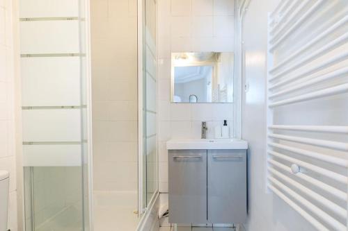 une salle de bain avec un lavabo et un miroir dans l'établissement Joli 2 pièces dans un agréable quartier de Paris, à Paris
