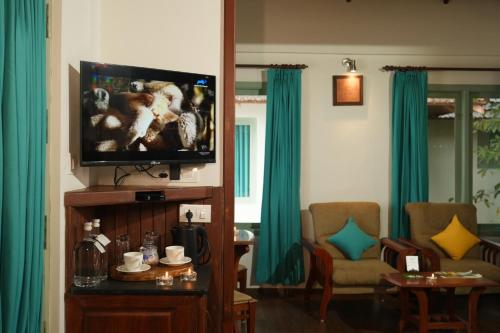 a living room with a flat screen tv and a couch at Blackberry Hills Munnar Nature Resort & Spa in Munnar