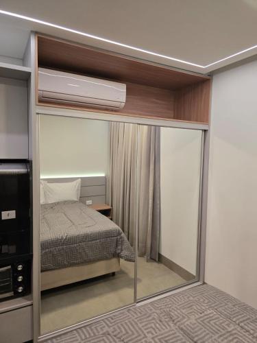 a bedroom with a bed and a mirror at Apto studio, coracao de maringa in Maringá