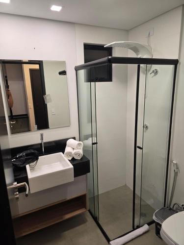 a bathroom with a sink and a shower at Apto studio, coracao de maringa in Maringá