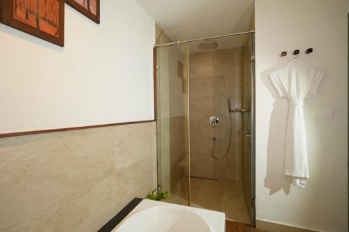 a bathroom with a shower with a wedding dress hanging on the wall at Blackberry Hills Munnar Nature Resort & Spa in Munnar