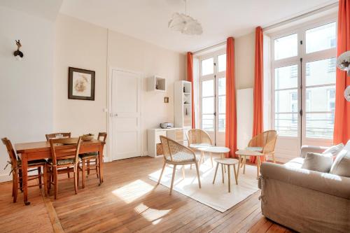 un salon avec une table, des chaises et un canapé dans l'établissement Au coeur du quartier Graslin, appartement pour 3, à Nantes